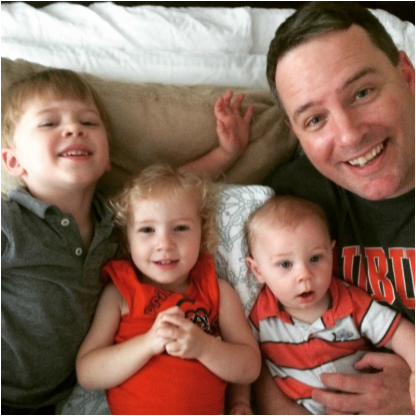 Picture of a dad with three kids.