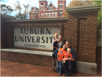 Family picture in front of the Auburn University sign. 
