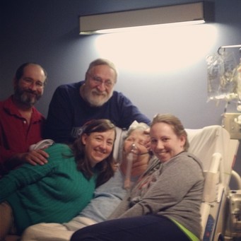 Picture of a family with their mom in the hospital.